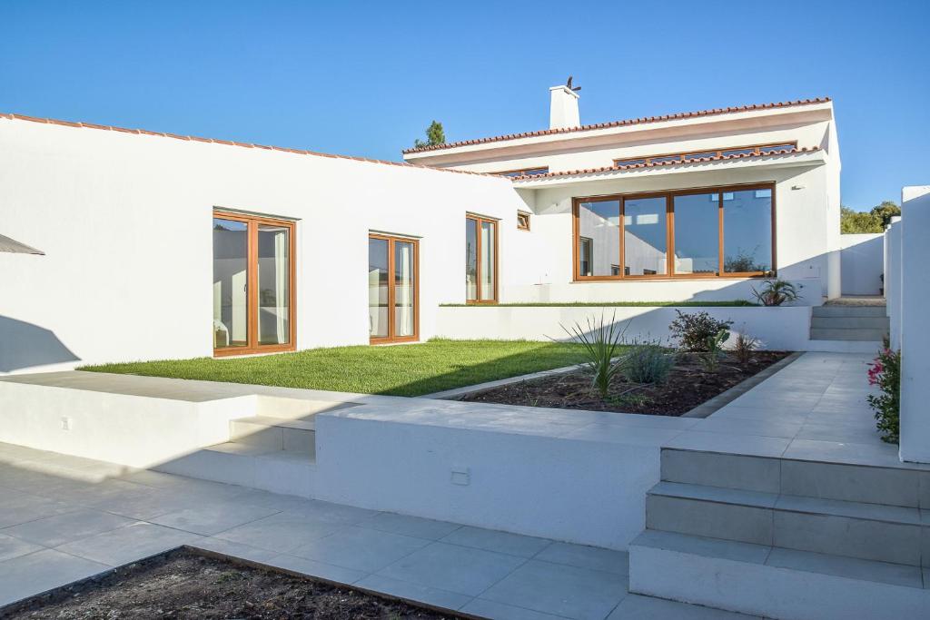 a white house with a garden in front of it at Casa Vista Verde by LovelyStay in Sesimbra