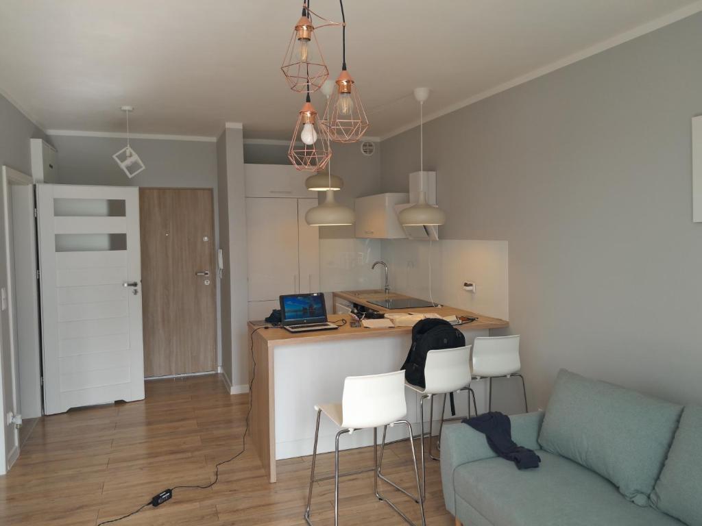 a living room with a couch and a kitchen at Apartament Panoramiczna "Sloneczny Balkon z Widokiem na caly Szczecin" in Szczecin