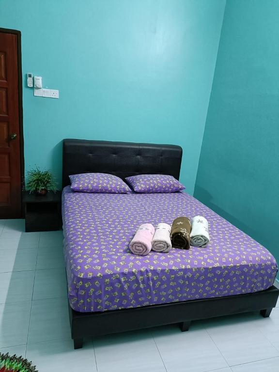 a bed with shoes on it in a room at Larut Tin Homestay in Taiping