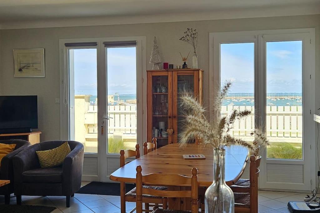 - un salon avec une table en bois et une vue sur l'océan dans l'établissement Maison de vacances vue mer et port plaisance, à La Richemondière