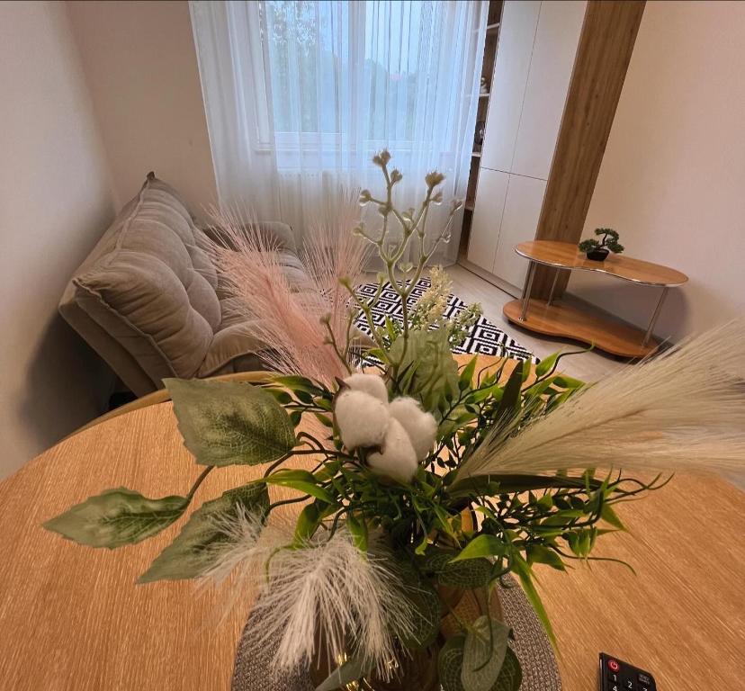 a vase of flowers on a table in a living room at Adam Home Ap in Fălticeni