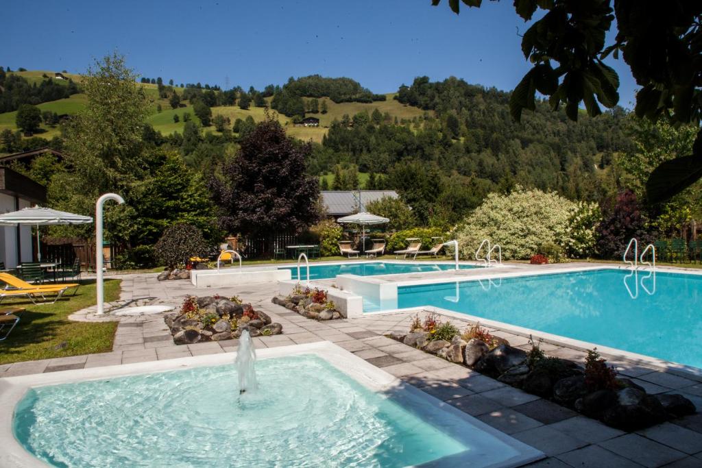 - une piscine avec une fontaine au milieu dans l'établissement Hotel-Gasthof "Zur Mühle", à Kaprun