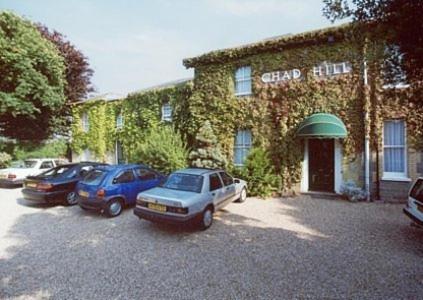 un grupo de coches estacionados frente a un edificio en Chad Hill Hotel, en Sandown