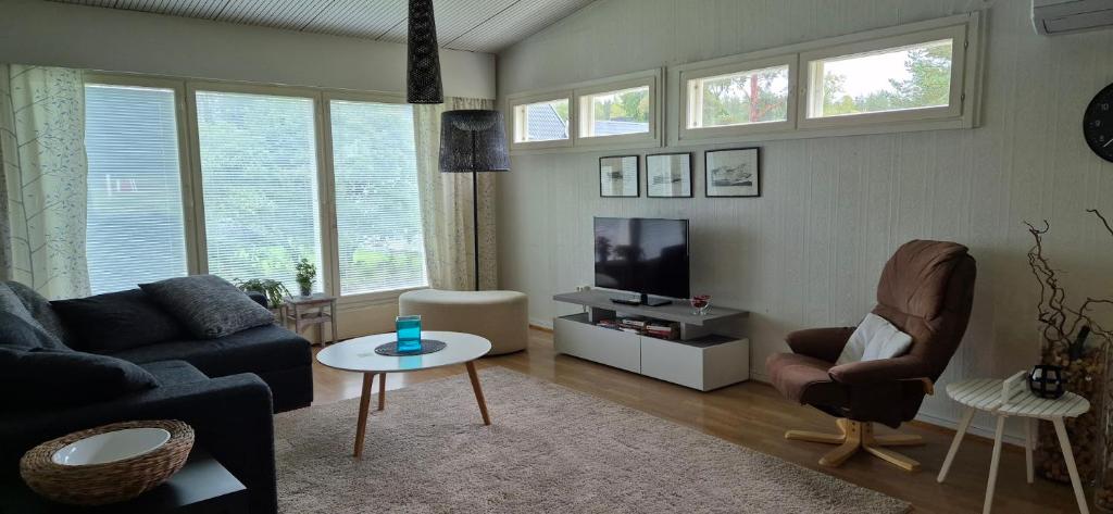 a living room with a couch and a tv at House with2 bedroom, bath, sauna, and big yard in Hyvinkää