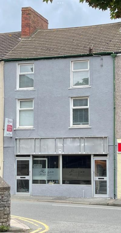 a gray building with windows on a street at HolyheadInn in Holyhead