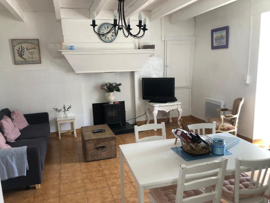 salon z kanapą i stołem w obiekcie Gîte des Lavandes w mieście Oradour-Fanais