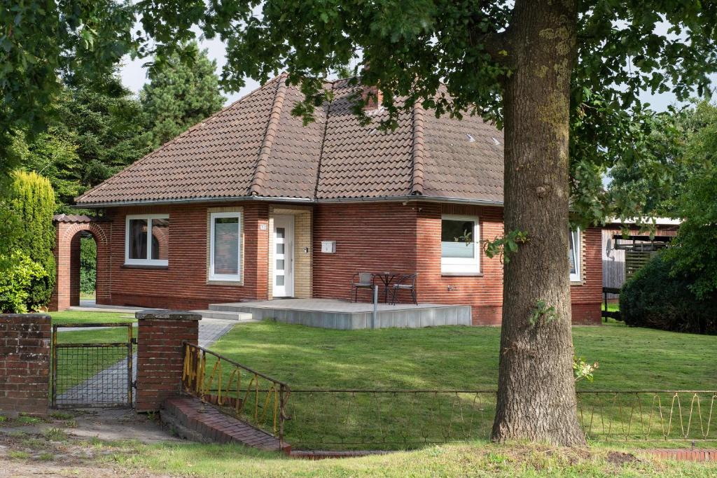 a brick house with a fence in front of it at Ferienhaus Anna Elbe in Wischhafen