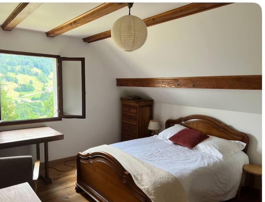 a bedroom with a bed and a window and a table at Maison montagne vue exceptionnelle En chartreuse in Entremont-le-Vieux