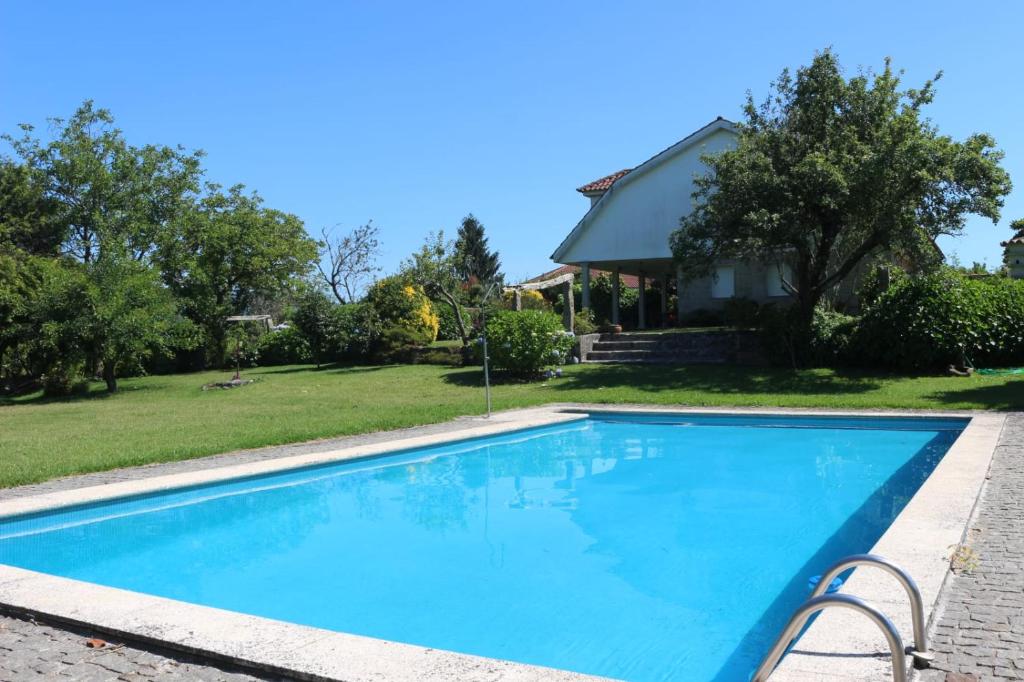 a swimming pool in front of a house at Chalet con piscina in Tui
