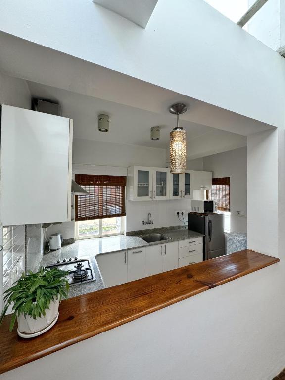 a kitchen with white cabinets and a wooden counter top at Ananya Apartments Phase 1 in Kathmandu