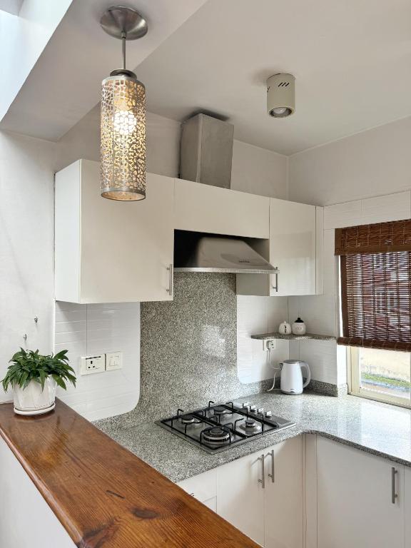 a kitchen with white cabinets and a stove top oven at Ananya Apartments Phase 1 in Kathmandu