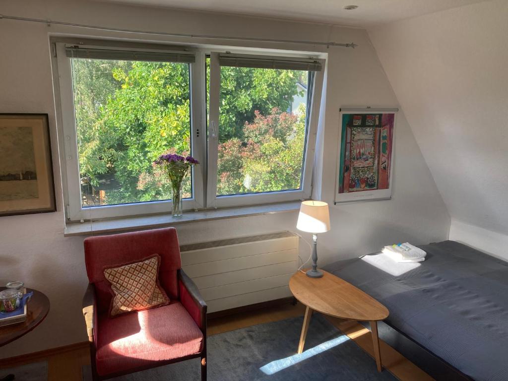 a bedroom with a bed and a chair and a window at Privatzimmer am Volkspark - Nähe Arenen und Trabrennbahn in Hamburg