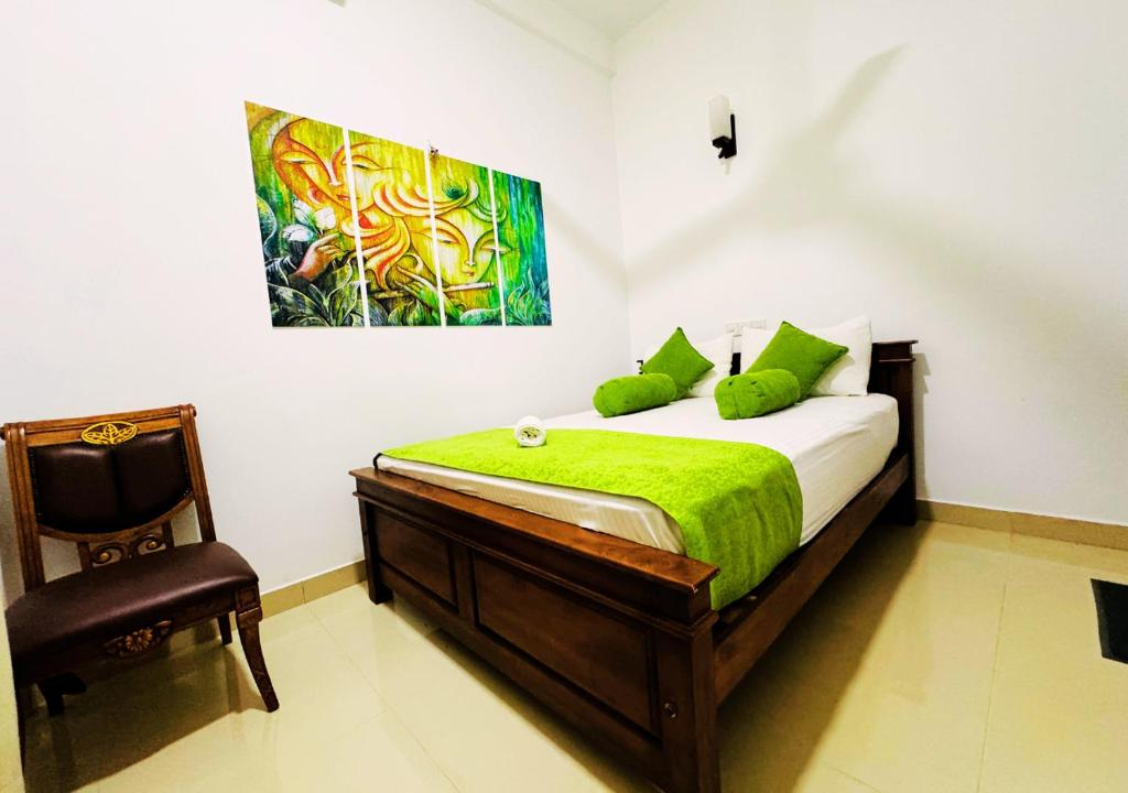 Un pat sau paturi într-o cameră la Anuradhapura Peacock Garden Holiday Bungalow