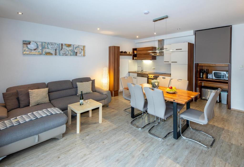 salon z kanapą i stołem z krzesłami w obiekcie Apartment-Alpenfantasie w mieście Zell am See