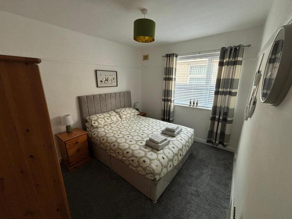a small bedroom with a bed and a window at Victoria Beach Cottage in Prestatyn