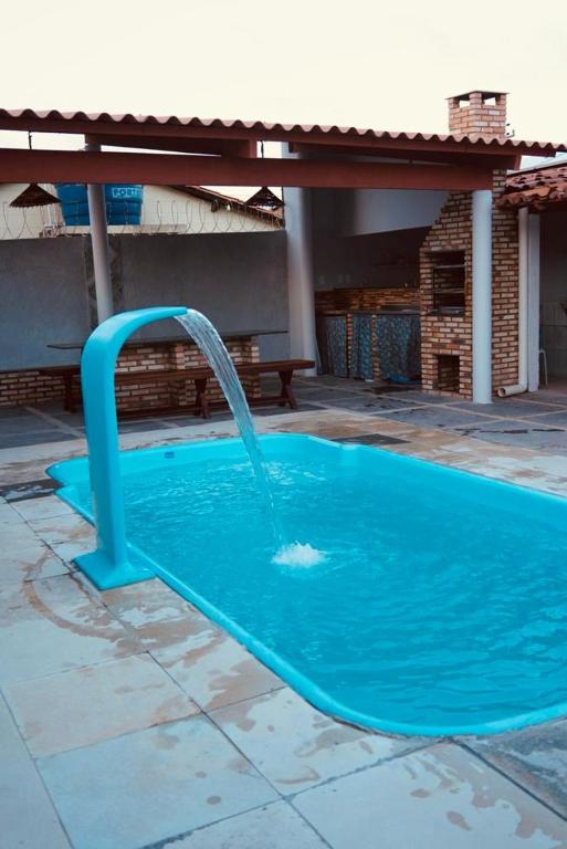 a blue pool with a water fountain at Casa de praia DM in Luis Correia