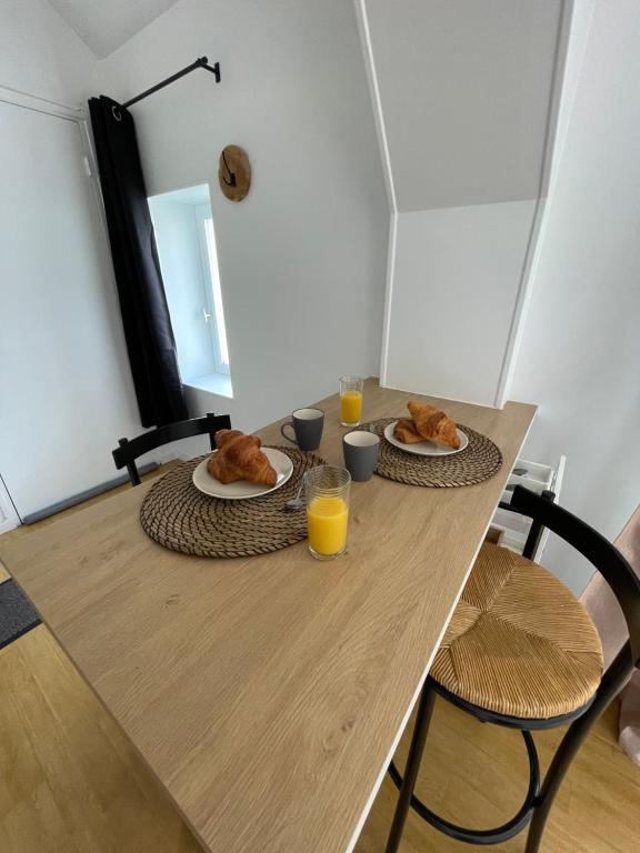a table with two plates of food and two glasses of orange juice at Modern Art Vierzon Centre ville in Vierzon