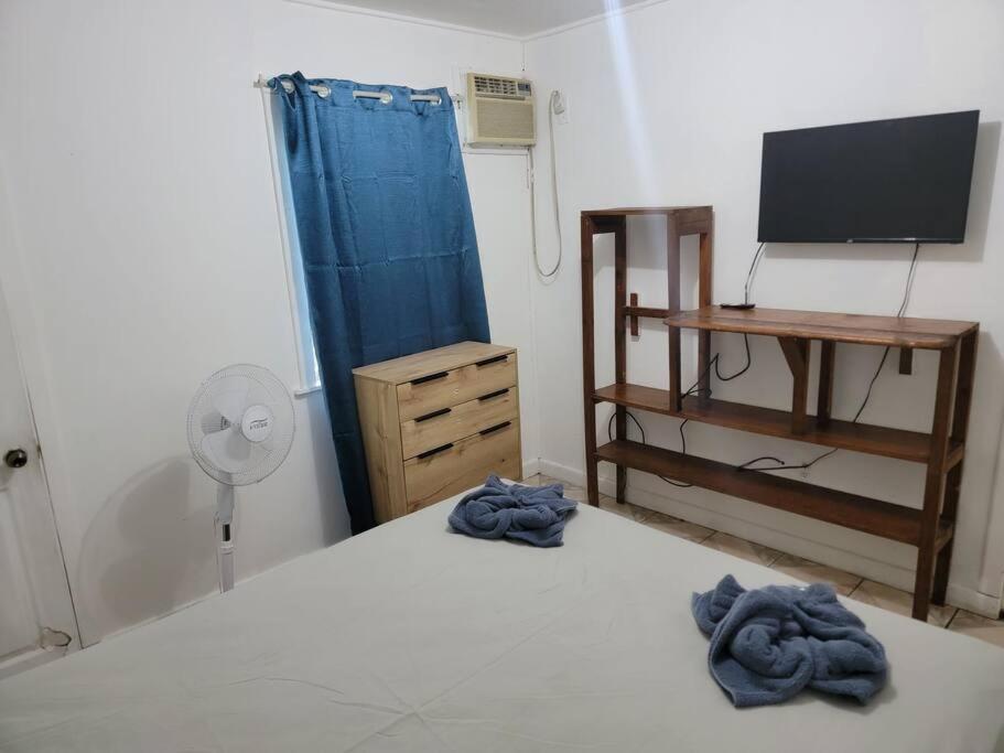 Un dormitorio con una cama, un escritorio y un televisor. en Apartment in center of town #1, en Utila
