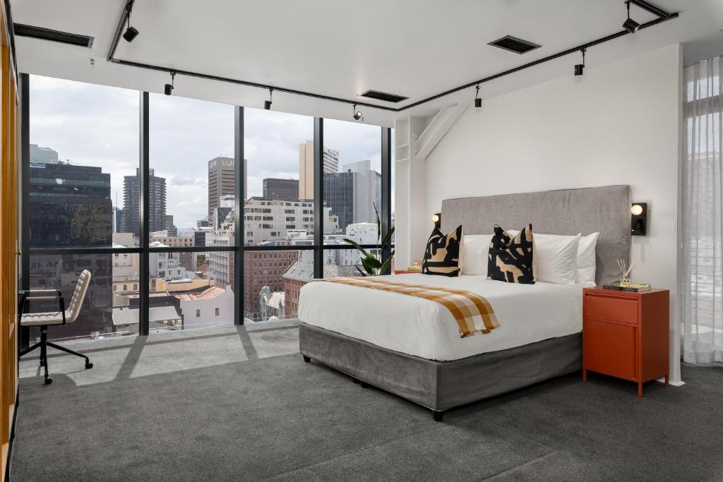 a bedroom with a large bed and a large window at Neighbourgood Loop Street in Cape Town