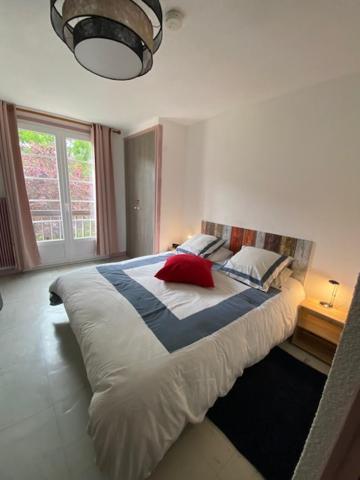 une chambre avec un grand lit avec une fenêtre dans l'établissement Appartement avec chambre séparée Résidence Auvergne, à La Bourboule