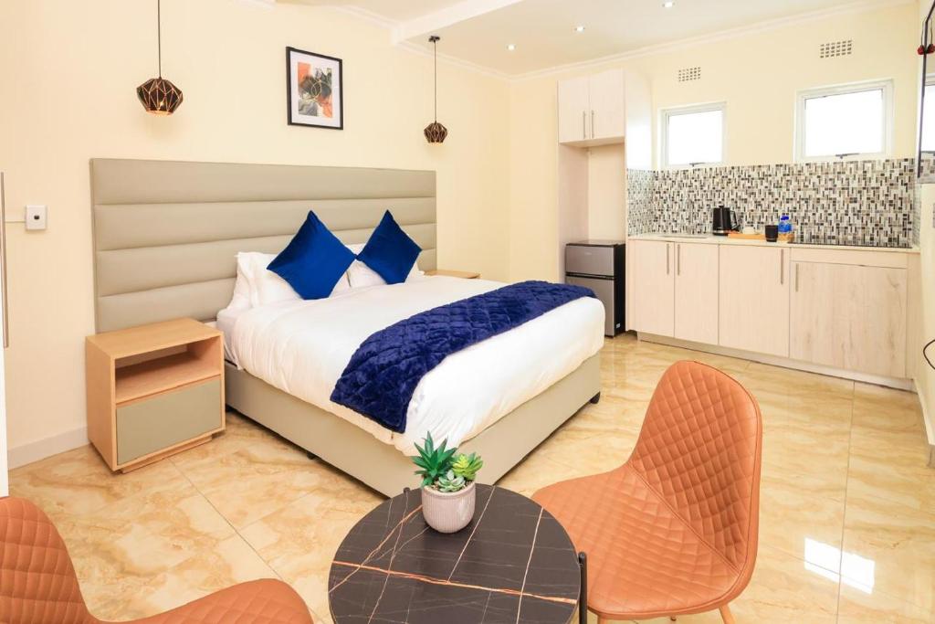 una camera con letto, tavolo e sedie di Clouds 52 Lodge a Johannesburg