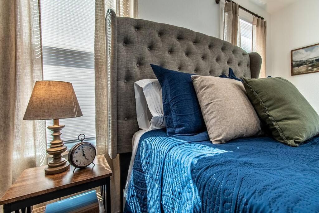 un letto con piumone blu e un orologio su un tavolo di Tranquil Terrace - Whole Duplex a Corpus Christi