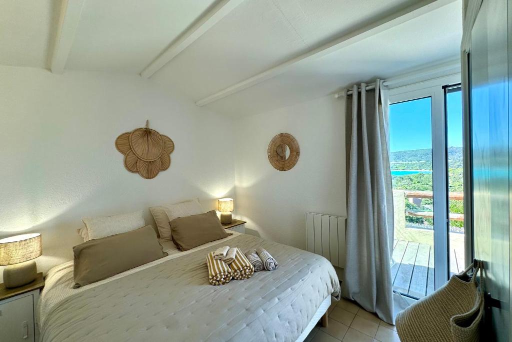 une chambre avec un lit avec vue sur l'océan dans l'établissement Adorable duplex vue mer 5 min à pied de Santa Giulia, à Porto-Vecchio
