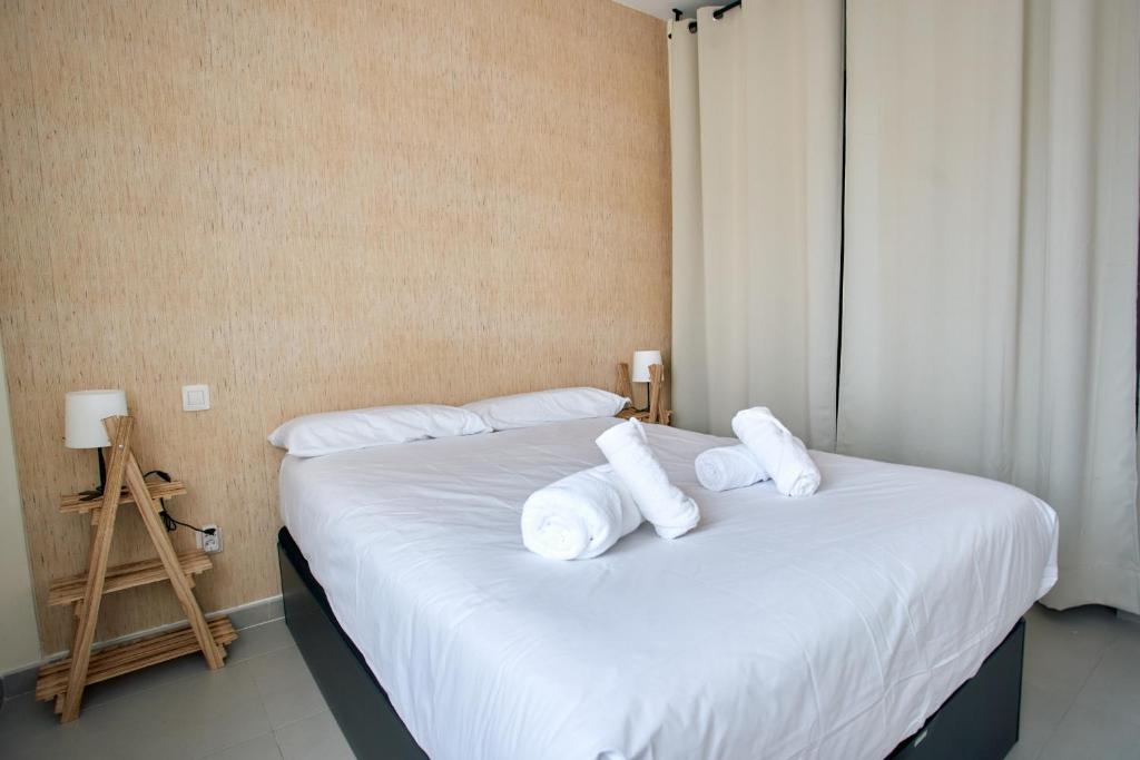 Un dormitorio con dos camas con sábanas y almohadas blancas. en Work & Pet friendly Urban Home next to the Beach, en Las Palmas de Gran Canaria