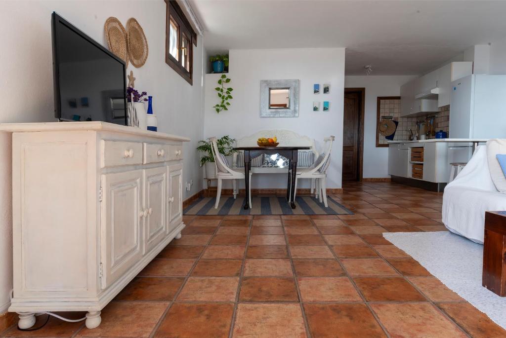 kuchnia i salon ze stołem i krzesłami w obiekcie Casa SocAire. Naturaleza, mar, paz, relax. w mieście Tabayesco