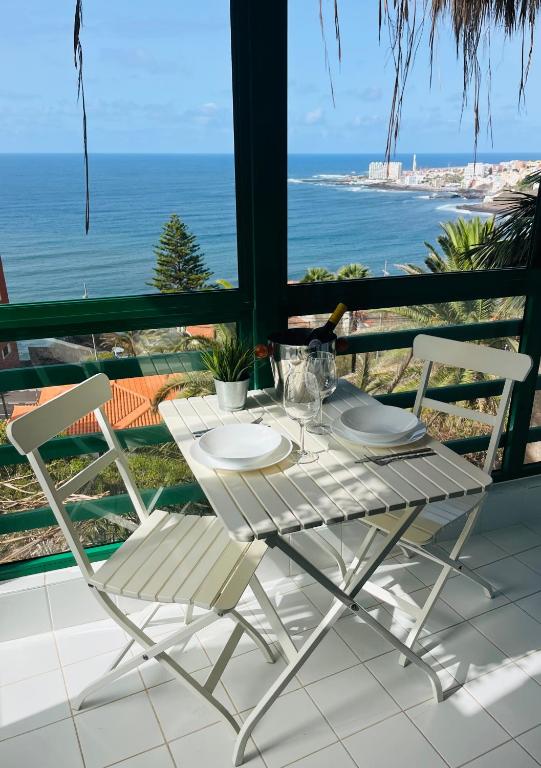 a table and chairs on a balcony with the ocean at The Green Terrace in Bajamar