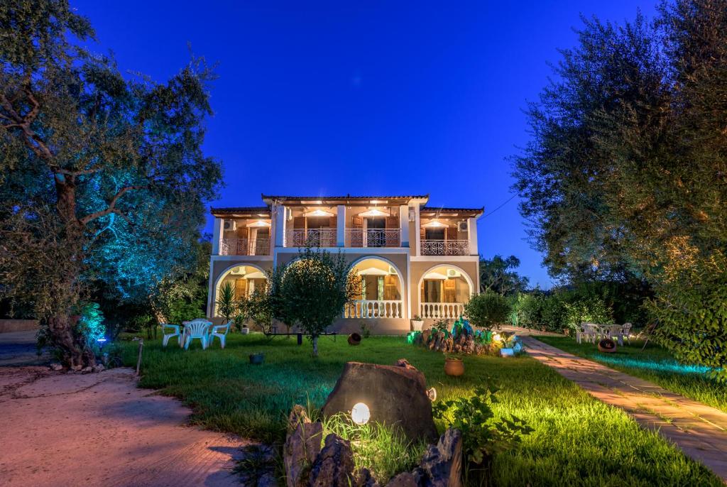 une grande maison avec une cour la nuit dans l'établissement Pansion Mary Studios, à Psarou