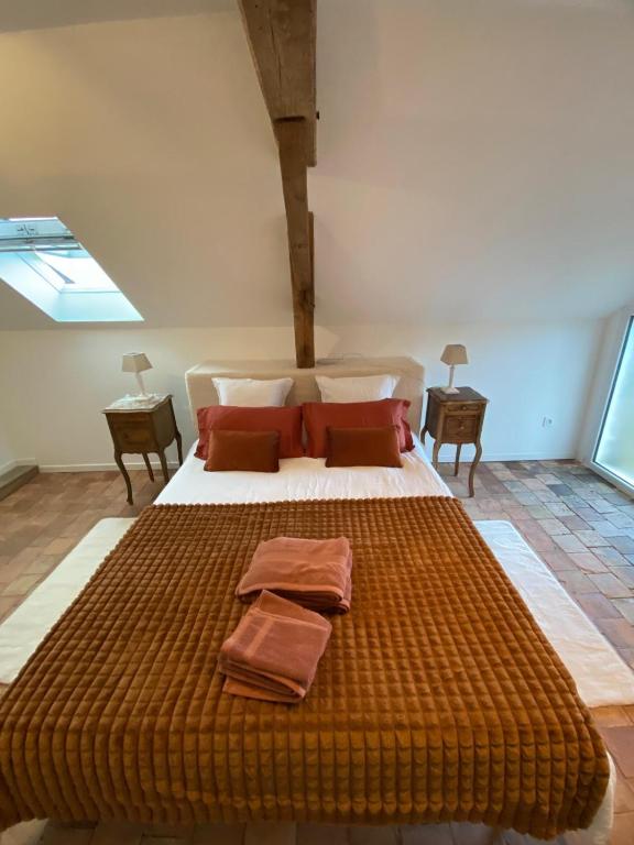 une chambre avec un grand lit avec deux oreillers dessus dans l'établissement L Ervélégance - Jardin DS - L'Harmonie Evénements House, à Sablé-sur-Sarthe