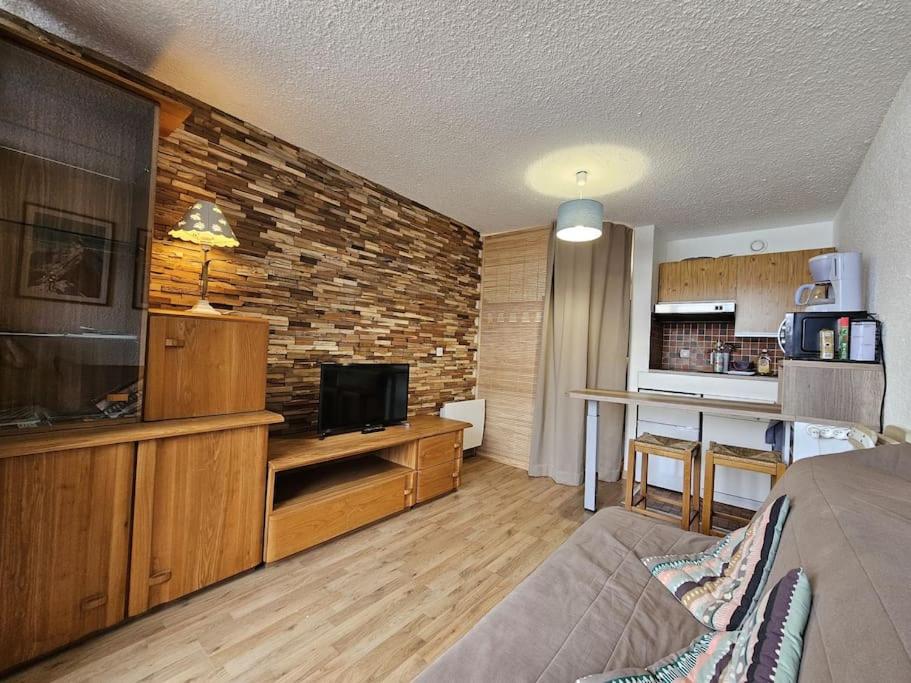 un salon avec un canapé et une télévision et une cuisine dans l'établissement studio plein SUD été comme hiver, aux Carroz d'Arâches