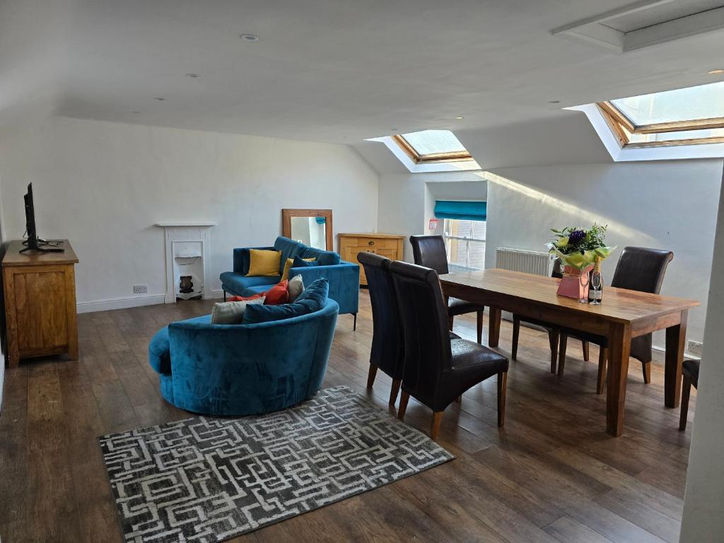 a living room with a blue couch and a table at Longden Court Mews in Buxton