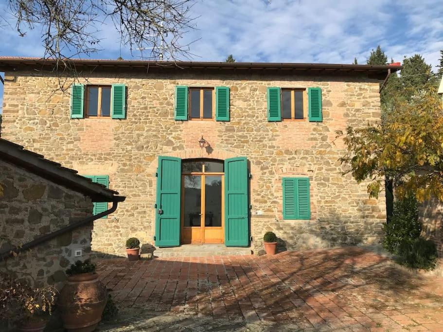 a stone house with green shutters and a door at Podere Solatio - Tuscany Hills next to Florence in Impruneta