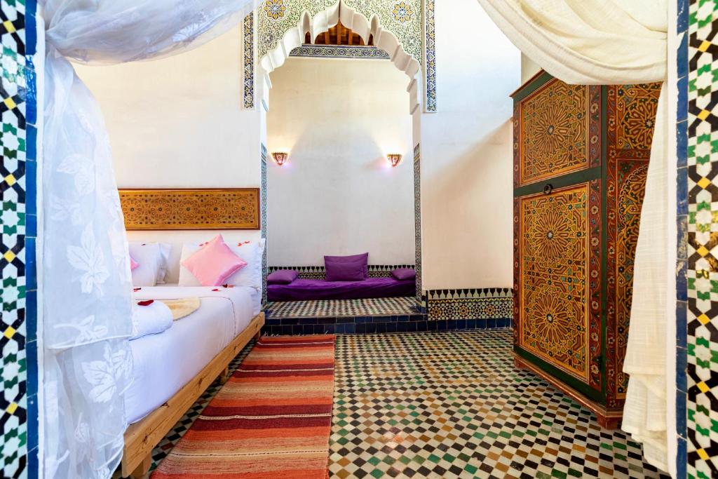 a room with a bed and a dresser in a room at Dar Attajalli in Fez