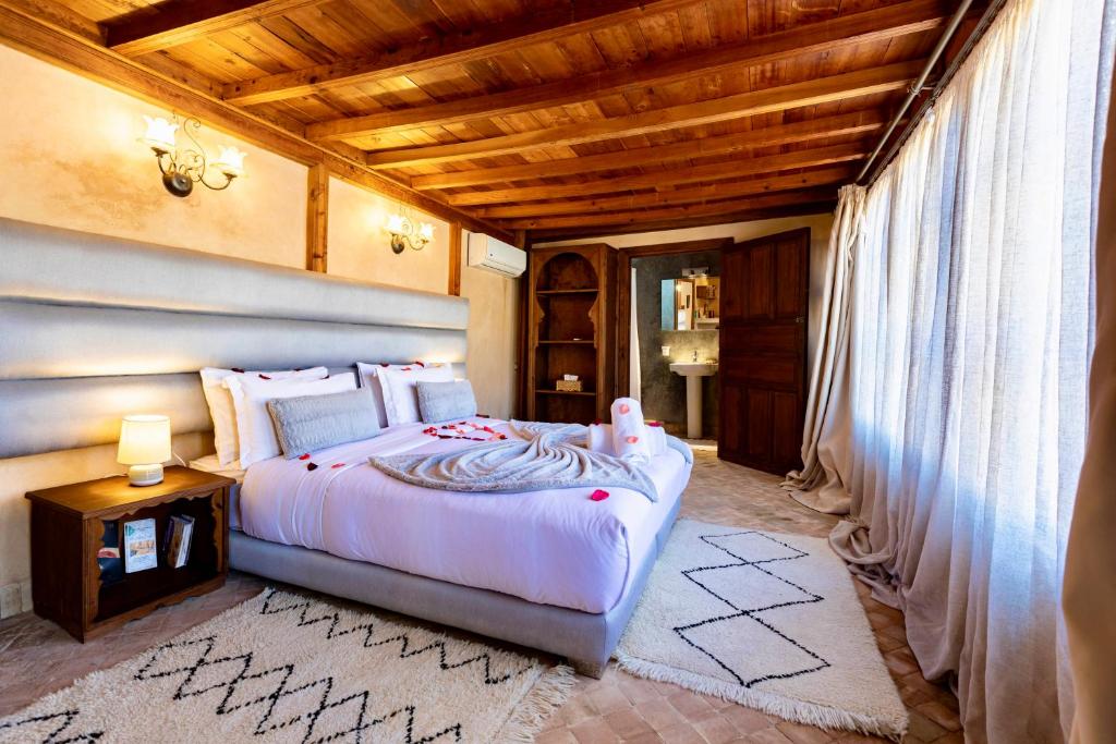 Un dormitorio con una cama y un techo de madera. en Dar Attajalli, en Fez