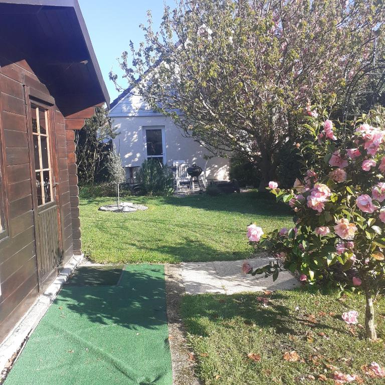 une maison avec une cour dotée d'une pelouse verdoyante dans l'établissement Au rosier de FRANCK, à Mesnil-Raoul