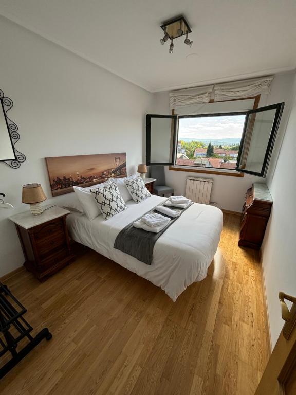 a bedroom with a large bed and a large window at El Rincón de Muxiña in Monforte de Lemos