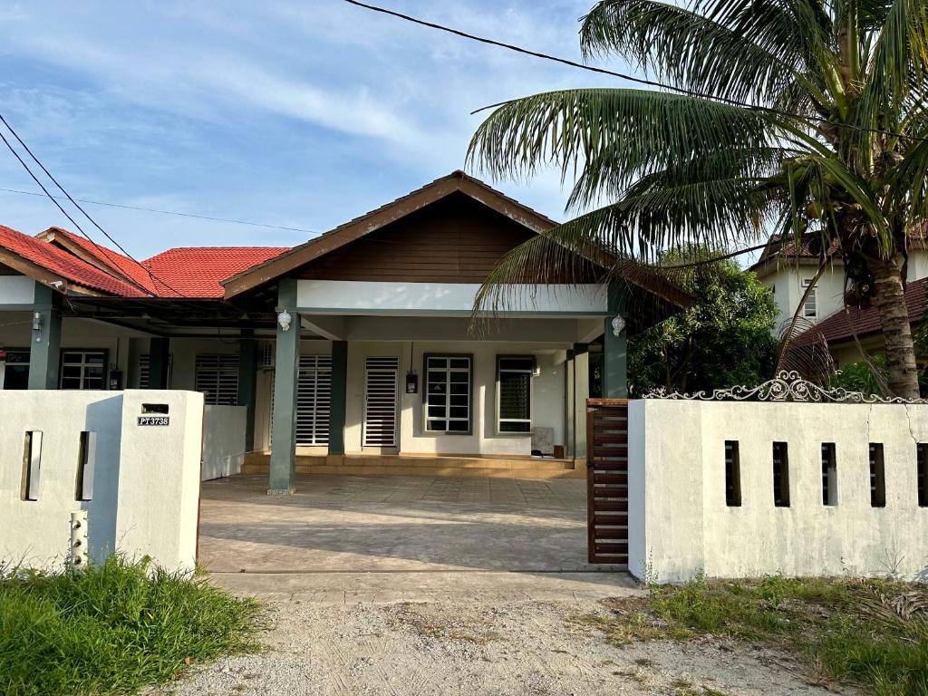 a house with a palm tree in front of it at SaRa Homestay in Kuala Terengganu