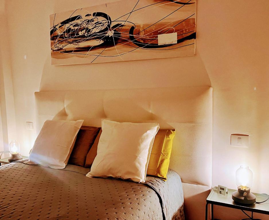 a bedroom with a bed with pillows and a painting at Melo Home 1 Near Airport, Elevator in Vecindario