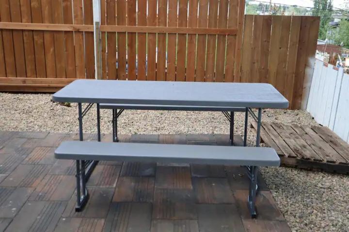 a blue picnic table sitting on a patio at Cute HighlandPark House in Calgary