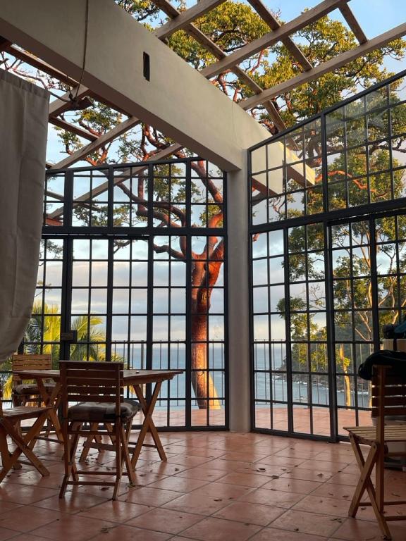 a room with a table and chairs and a large window at Sky Temple Yelapa in Yelapa