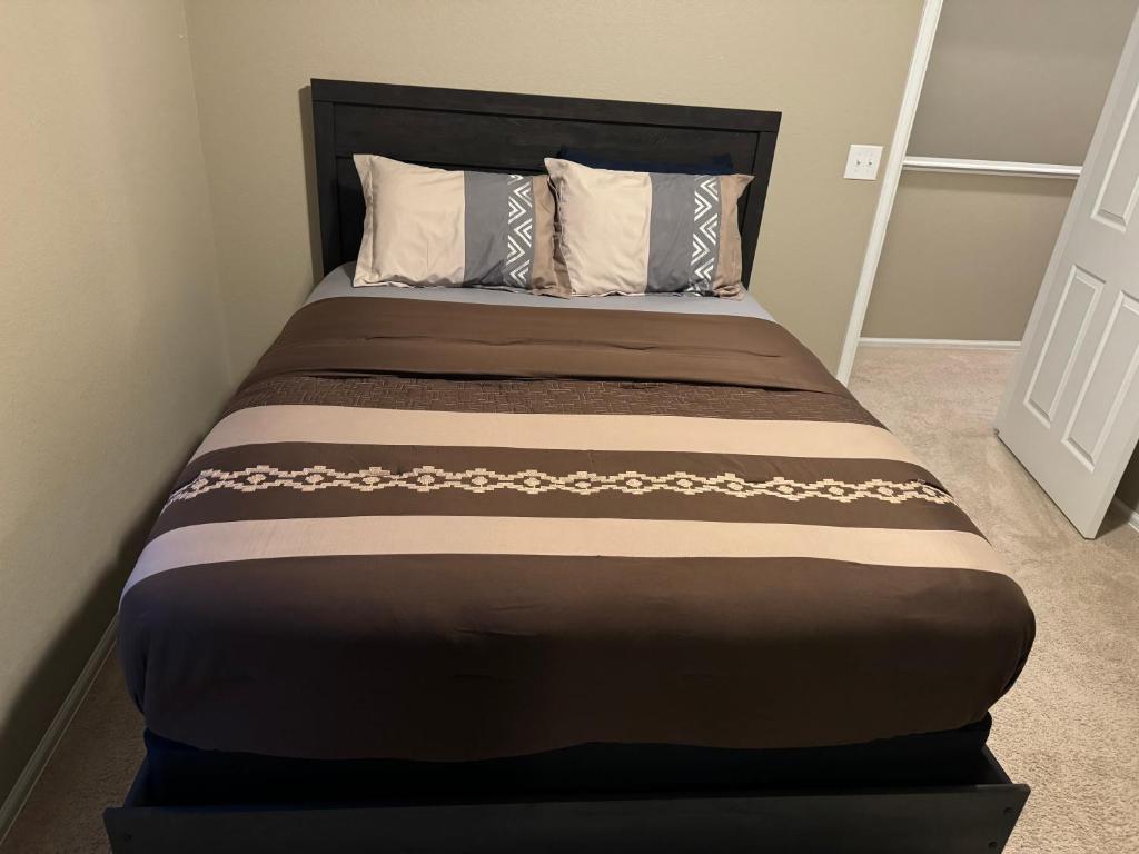 オーロラにあるHumble Homeのブラウンのベッドが備わるベッドルームのベッド1台分です。