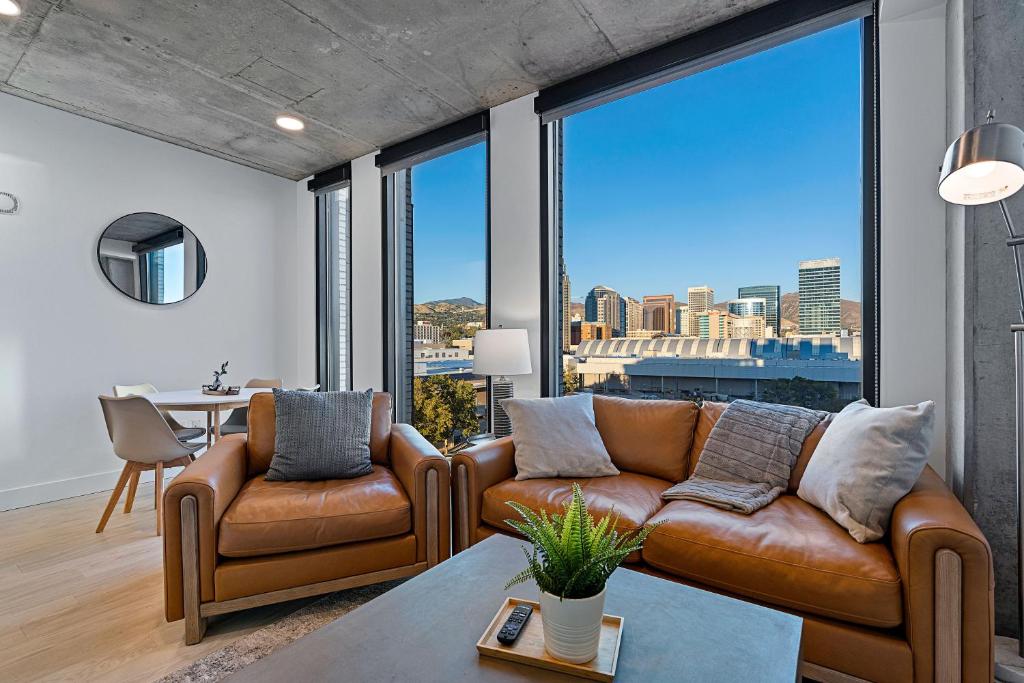 a living room with two couches and a large window at 8th fl Amazing views! Lux design! Pool gym Pkg! in Salt Lake City