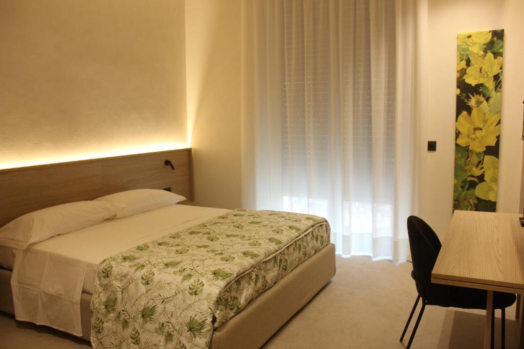 una camera da letto con un letto, un tavolo e una scrivania di GRAFEA Apartment&Rooms Catania a Catania
