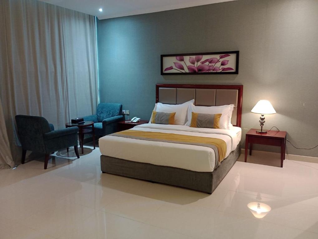 a bedroom with a bed and a desk and a chair at Taleen Serviced Apartments Al-Ahsa- تالين الاحساء للشقق المخدومة in Ruqaiqah