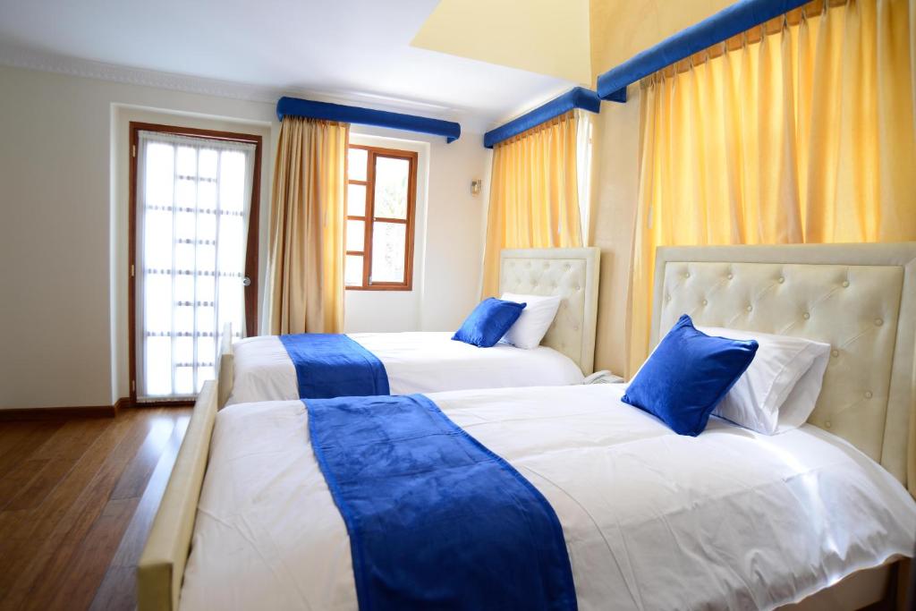 2 camas en una habitación de color azul y blanco en Marquiz Hotel Boutique, en Quito