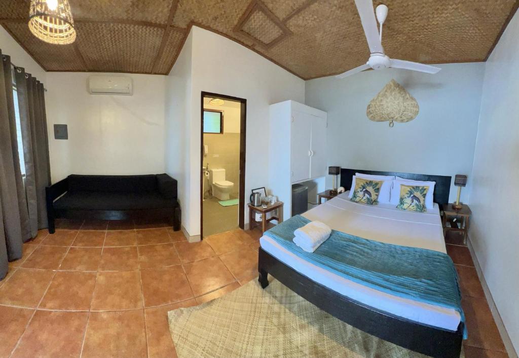 a bedroom with a large bed and a bathroom at Golden Monkey Beach Hotel in El Nido