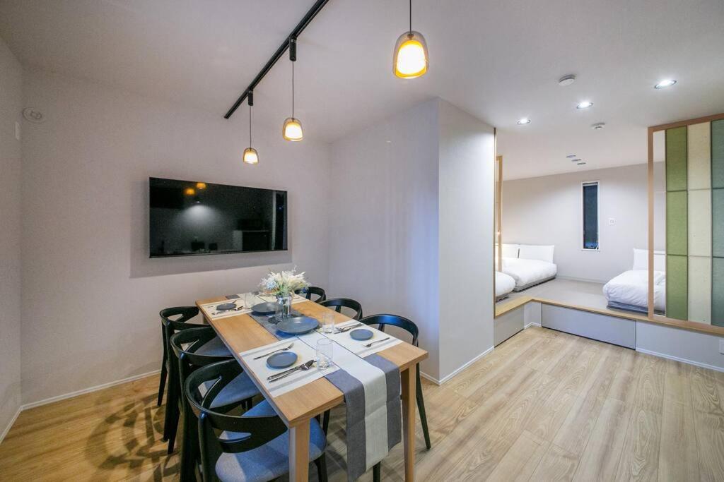 a room with a dining table and a bedroom at T-home彩 in Tokyo